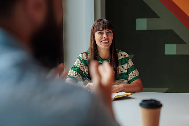 istock Young businesswoman taking notes and smiling during a meeting 2221219633
