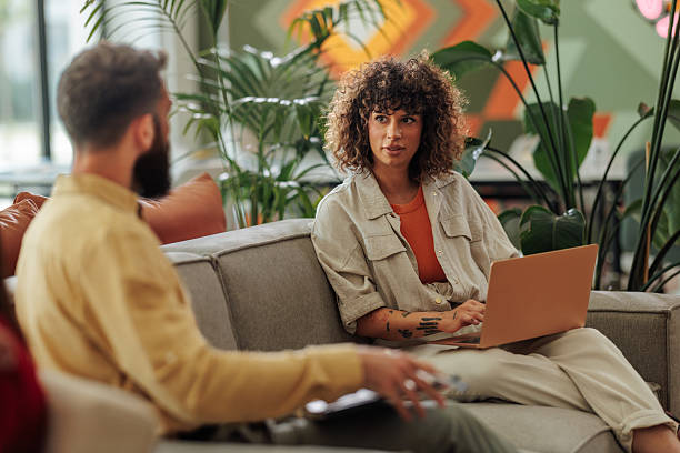 istock Young colleagues discussing a project using a laptop in a modern office 2221219671