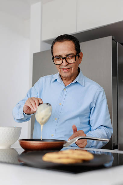 istock Senior man cooking pancakes in home kitchen 2221221937