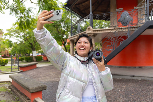 Woman taking a selfie with her old 35mm camera