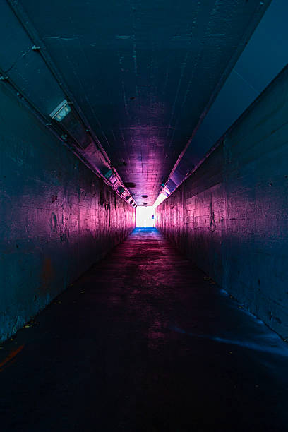 istock Long dark empty tunnel walkway with light at the end. 2221235691