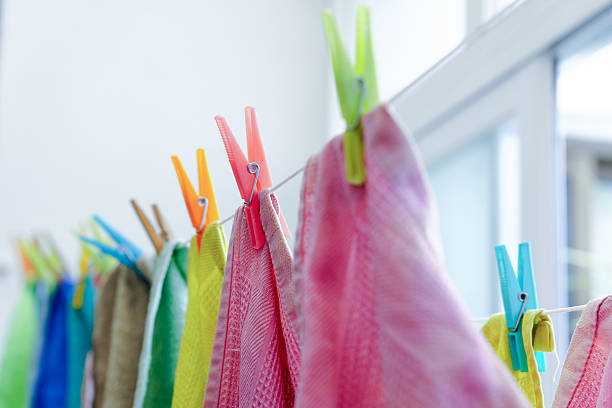 Clean colorful cloths are hanging on a clothesline and drying in the sun