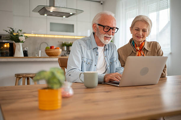 istock Happy senior couple using laptop at home in the kitchen 2221238934