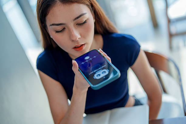 Young woman interacts with smartphone, using voice assistant feature. scene captures her focused expression as she engages with technology, showcasing integration of AI and chatbots in daily life
