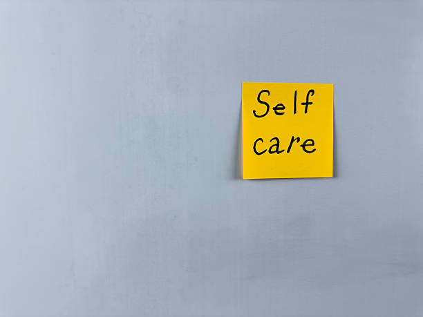 Sticky note with the words Self Care written on it, placed on white background. Ideal for illustrating themes of well being, health, and self love. Great for concept creation