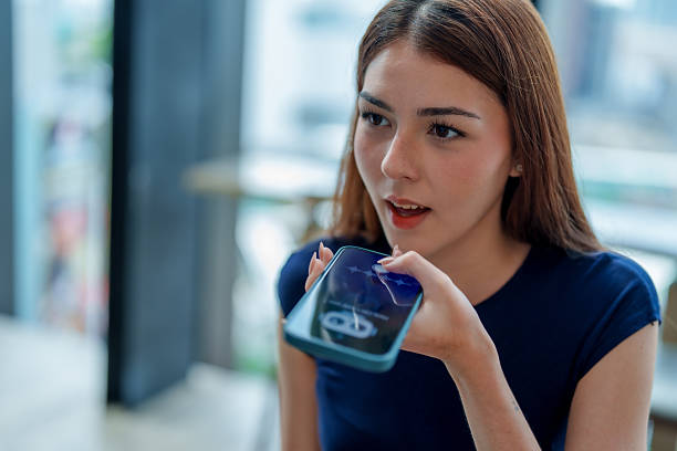 istock Young woman is using smartphone to interact with digital assistant, showcasing integration of technology daily life. This scene highlights convenience of AI and chatbot features modern 2221256689