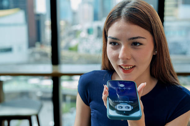 istock Young woman is using smartphone to interact with chatbot assistant modern urban setting. scene captures her engaged expression as she communicates with AI technology, showcasing integration 2221256722
