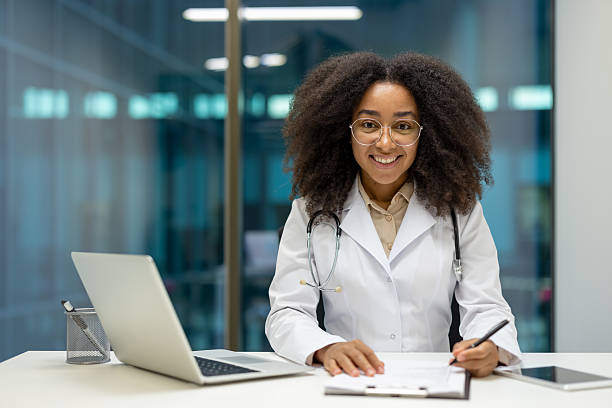istock A beautiful black doctor smiles at the camera while working in her office setting. 2221264023