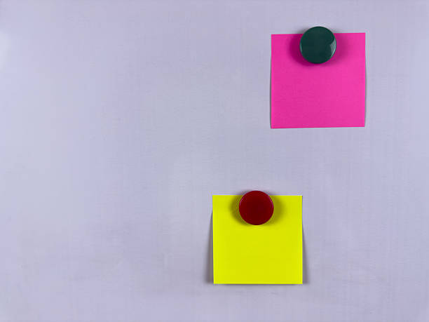 istock Pink and yellow sticky notes with magnets on whiteboard perfect for reminders and scheduling in various settings providing a colorful solution for organization and communication 2221264581