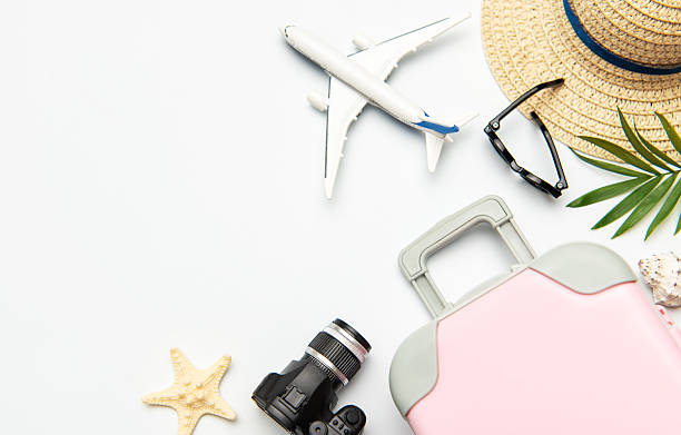 istock Pink suitcase, camera, sunglasses and airplane model suggesting summer vacation planning 2221269309
