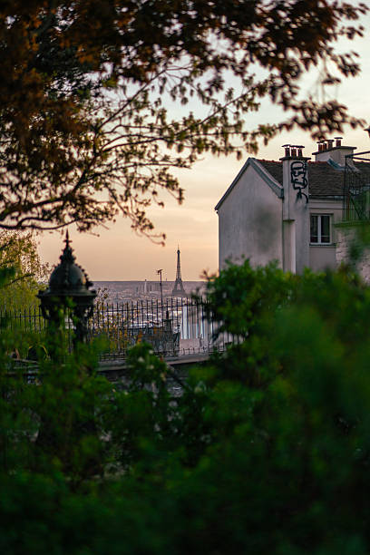 istock The Eiffel Tower seen in the distance through trees and rooftops at dusk in Paris. 2221271483