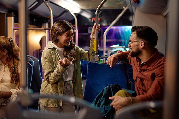 istock Young woman talking to a man while standing on a bus 2221272498