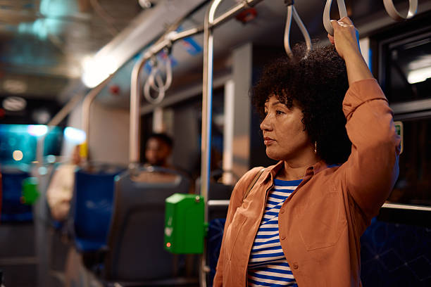 istock Woman commuting by bus holding the handle while looking out the window 2221272641