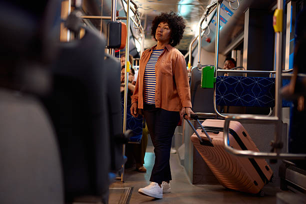 istock Woman traveling by bus pulling a trolley suitcase 2221272689