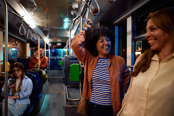 istock Two cheerful multi-ethnic women chatting while commuting by bus at night 2221272736