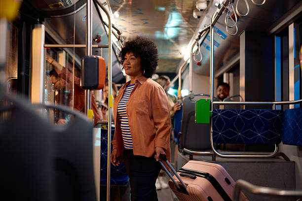 istock Woman traveling by bus pulling a trolley suitcase 2221272742
