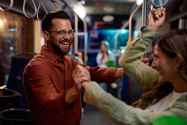 istock Young couple holding hands and laughing while commuting by bus 2221272744