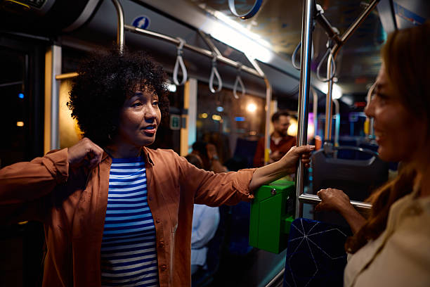 istock Two multi-ethnic women chatting while standing on a bus at night 2221272851