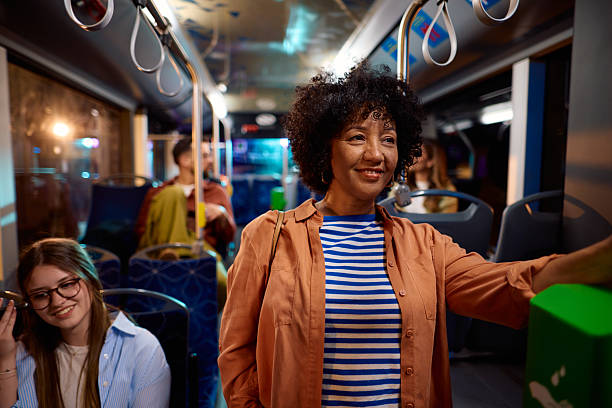 istock Smiling woman commuting by bus at night 2221272852