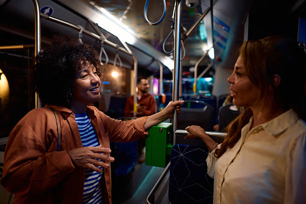 istock Two multi-ethnic female friends chatting while standing on a bus at night 2221272886