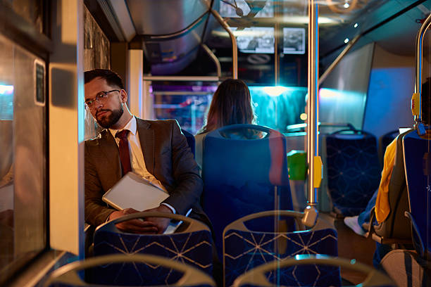 Tired businessman sleeping while commuting by bus at night