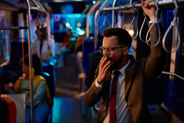 istock Tired businessman yawning while commuting by bus at night 2221272935