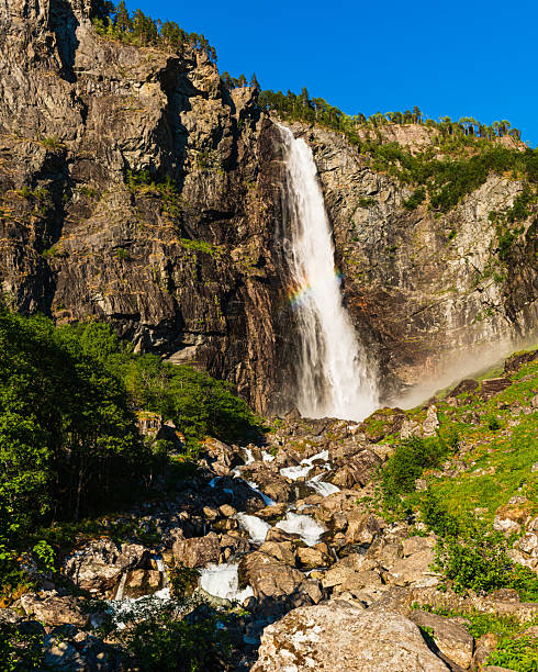 istock Majestic Feigefossen waterfall cascades down cliffs in Norway under clear blue sky 2221273250