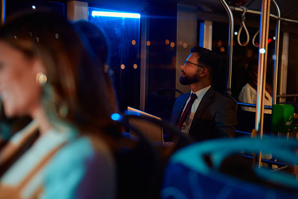 istock Businessman commuting at night on a bus looking out the window 2221274633