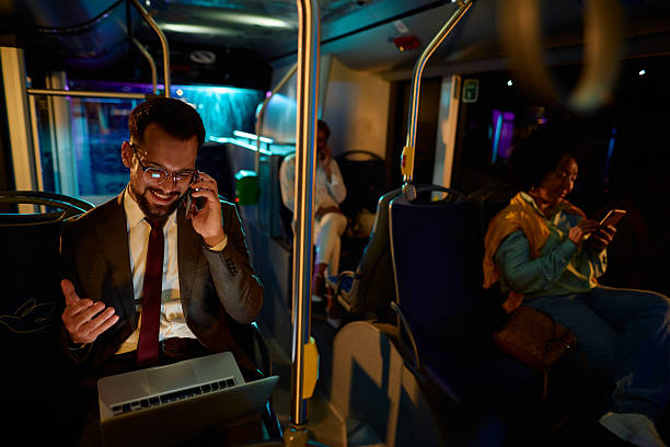 istock Businessman working late and using laptop and phone while commuting by bus 2221274662