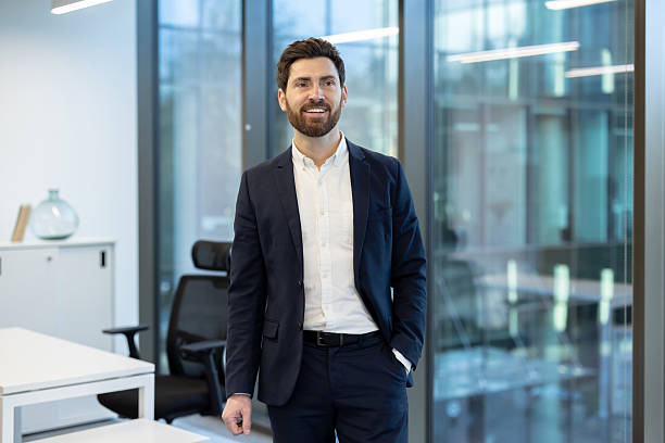 istock A smiling, successful businessman poses in a bright, modern office environment, looking confident. 2221280701