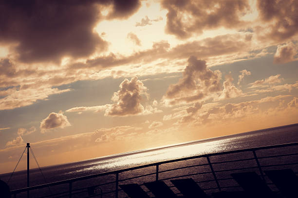 Wooden deck and railing from cruise ship. Beautiful sunset and ocean view.