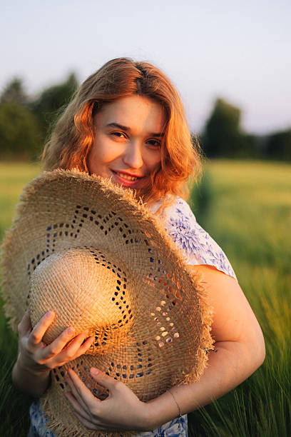 istock Mysterious Redhead in Straw Hat Amidst Golden Sunset Field 2221281481
