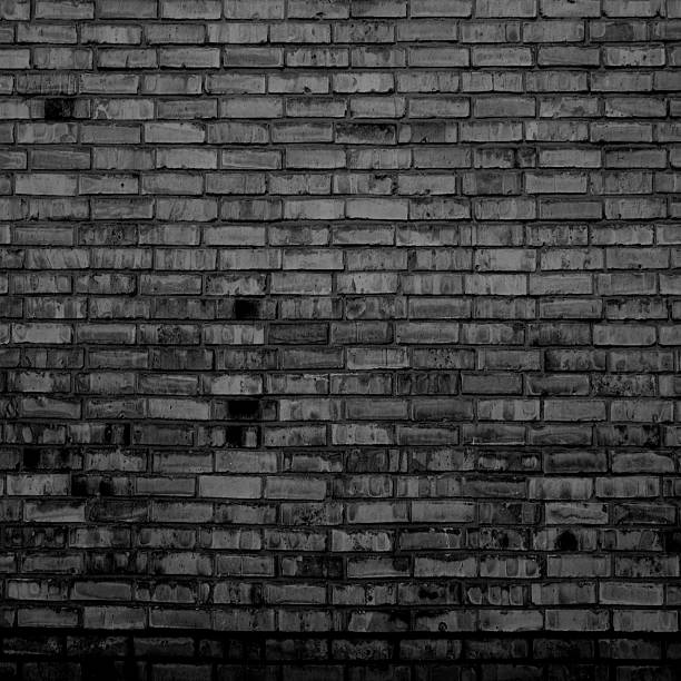 istock Black brick wall backgrund with weathered old stones 2221284348