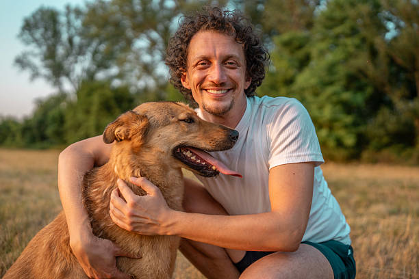 istock Smiling Man Enjoying a Sunny Day Outdoors Bonding with His Happy Dog 2221288719