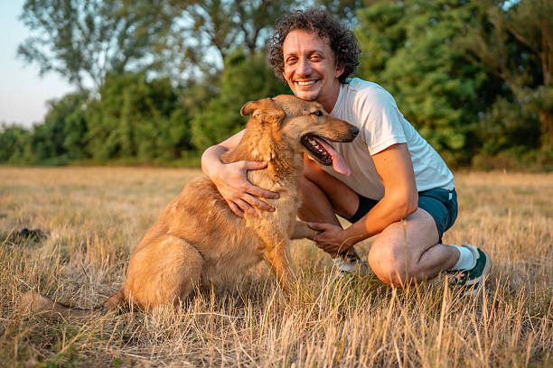 istock Man and Dog Enjoying a Moment Outdoors in a Field Setting 2221288720