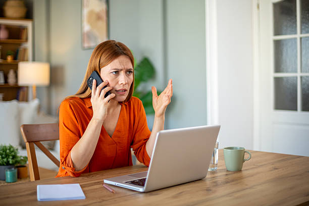 istock Frustrated woman arguing on phone while working from home 2221288774