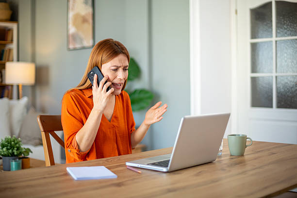 istock Stressed businesswoman arguing on phone while working at home 2221288775