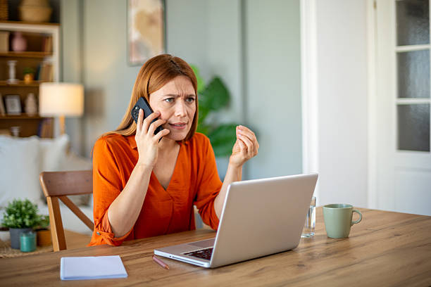 istock Stressed businesswoman arguing on phone while working at home 2221288885