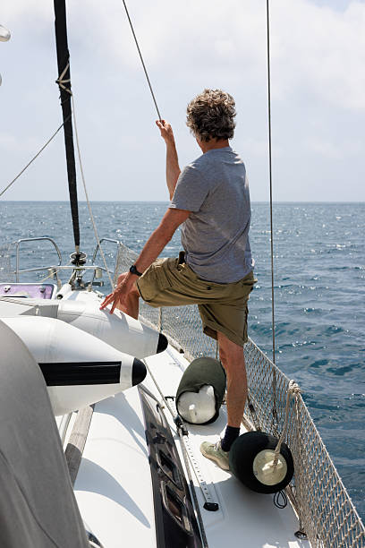 istock Mature man sailing in the Costa Brava, adjusting sails on a sunny day 2221293811