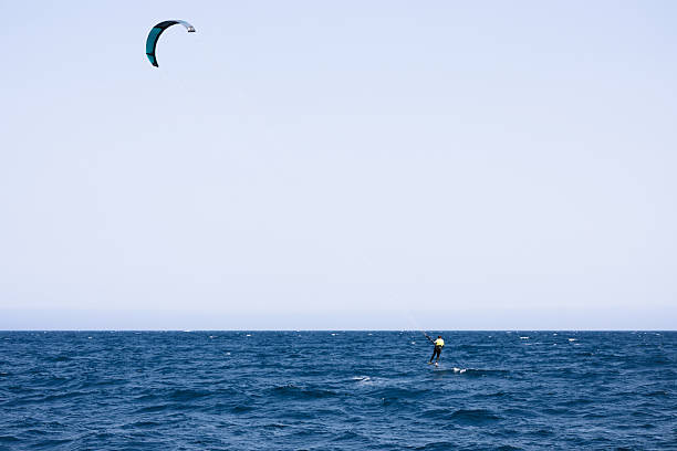 Athlete kitesurfing with hydrofoil in the mediterranean sea near Rosas, in the Costa Brava, Catalonia, Spain