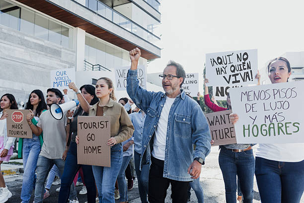 Group of Hispanic people activists protesting against high housing costs in Mexico City, women and men marching on streets for human rights and Housing crisis in Latin America stock photo
