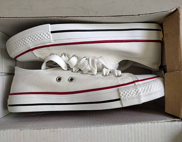 istock Women's sneakers in an open shoe box. Unpacking, top view 2221300011