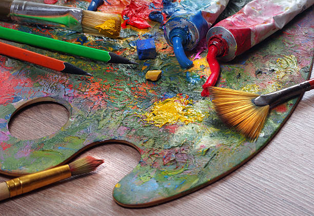 artist's palette, tubes and brushes on a table