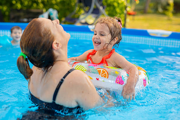 istock Happy Mother and Daughter Enjoying Summer Fun in Backyard Pool 2221305532