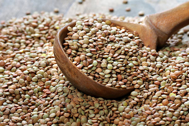 istock lentils in a wooden spoon close-up 2221324994