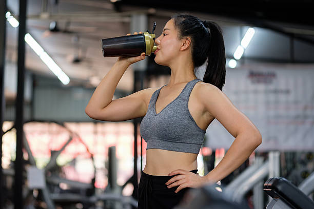 istock Young athletic woman in activewear drinks a protein shake after workout in a modern gym. 2221325199