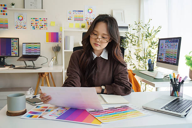 istock Female graphic designer examining  color samples and working on creative projects in a modern office. 2221325555