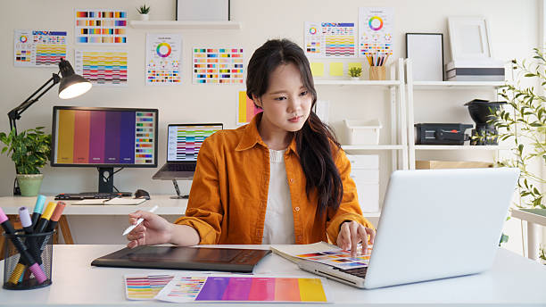 istock Asian female graphic designer working on digital artwork at a creative workspace. 2221325600