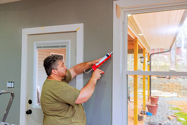 istock Man applying caulk to windows during home renovation project in well lit room 2221325761