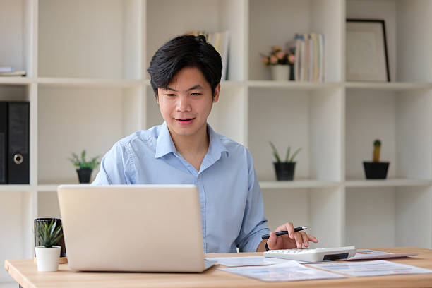 istock Businessman calculating expenses or budgeting while reviewing reports on his workspace. 2221326783